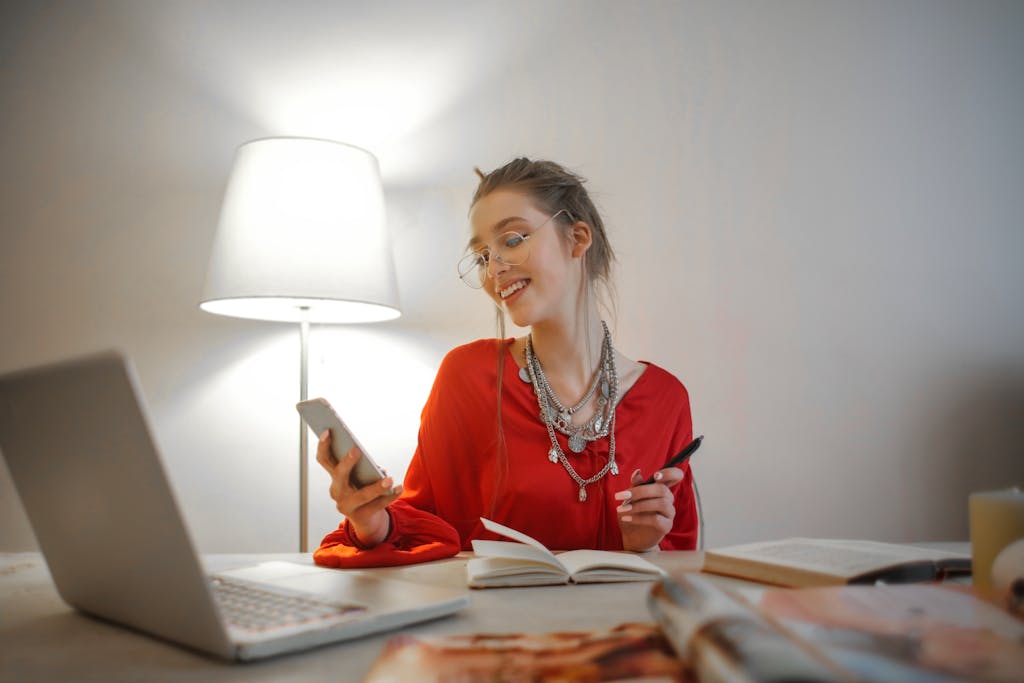 Young woman in red smiling, multitasking, enjoying her personal path.